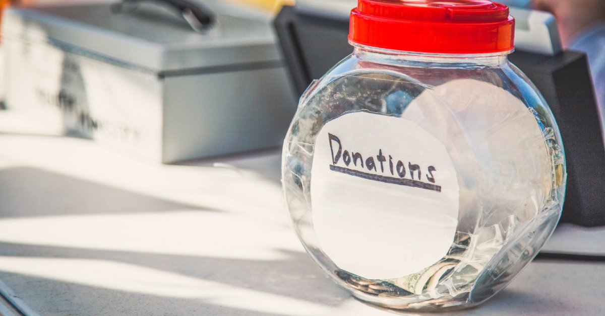 There's a jar labeled for donations on a small fundraising table. In the background, you can see a cash box.